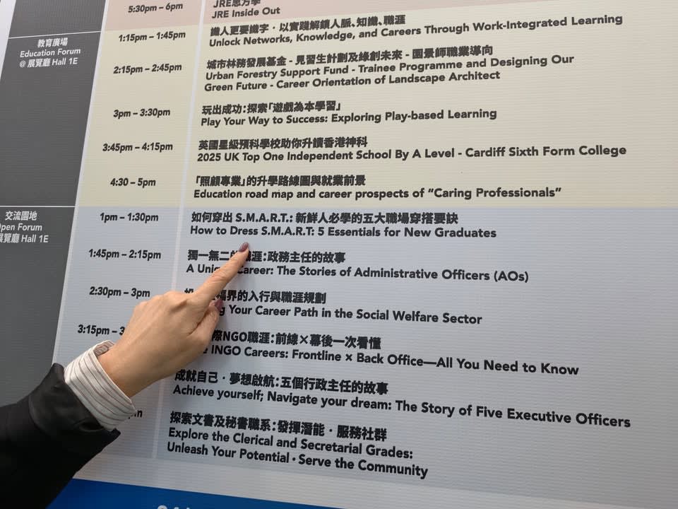 A hand pointing to a session titled "How to Dress S.M.A.R.T.: 5 Essentials for New Graduates" on an event schedule.